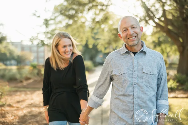 The podcast hosts walking hand-in-hand outdoors